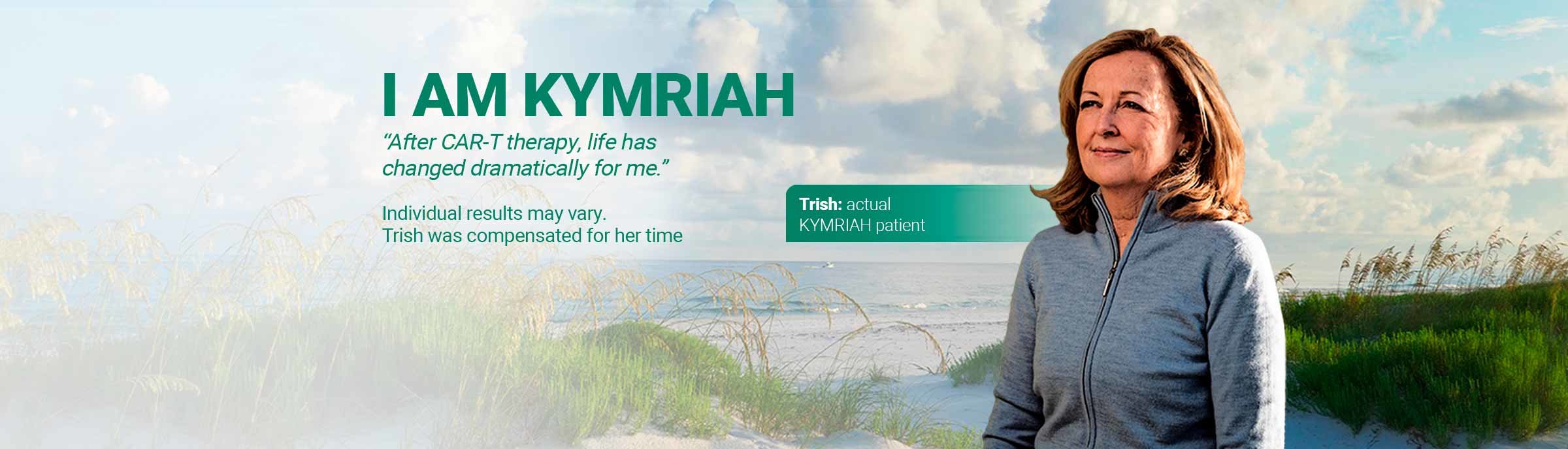 Image shows Trish, an actual KYMRIAH® patient standing in sand dunes close to the sea. She is smiling and looking into the distance to the left. She wears a grey casual zip up top and has light brown, shoulder length hair.